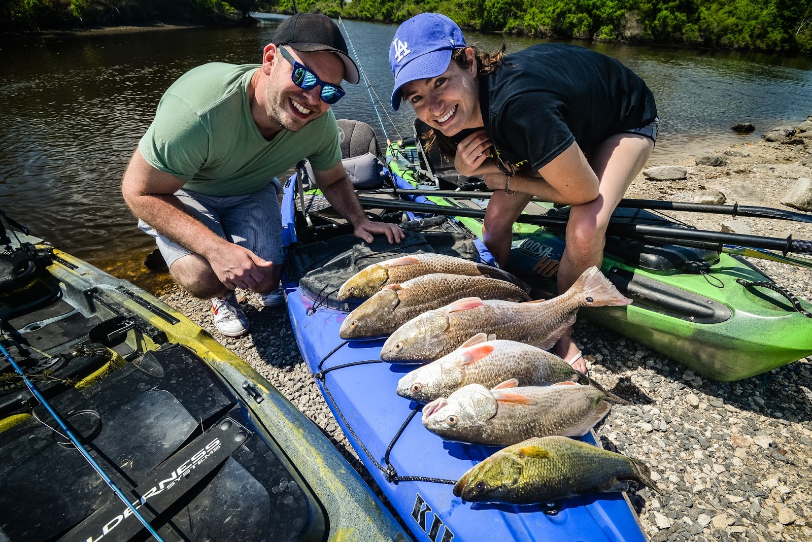 A man and woman showing off their catch of 6 fish caught during Inshore Kayak Fishing Charter