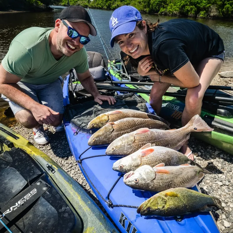 A man and woman showing off their catch of 6 fish caught during Inshore Kayak Fishing Charter