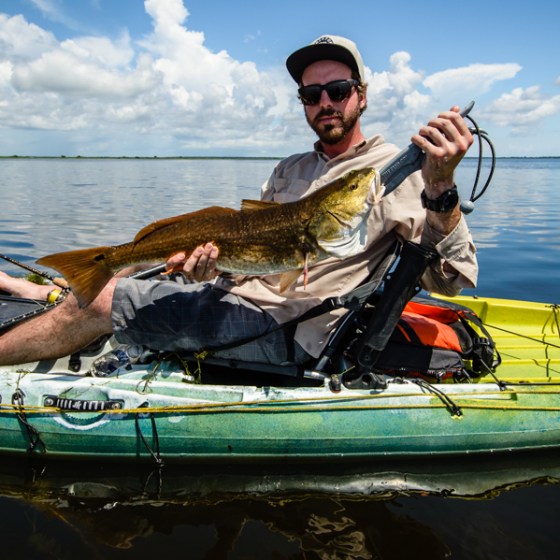A man showing a fish in a kayak